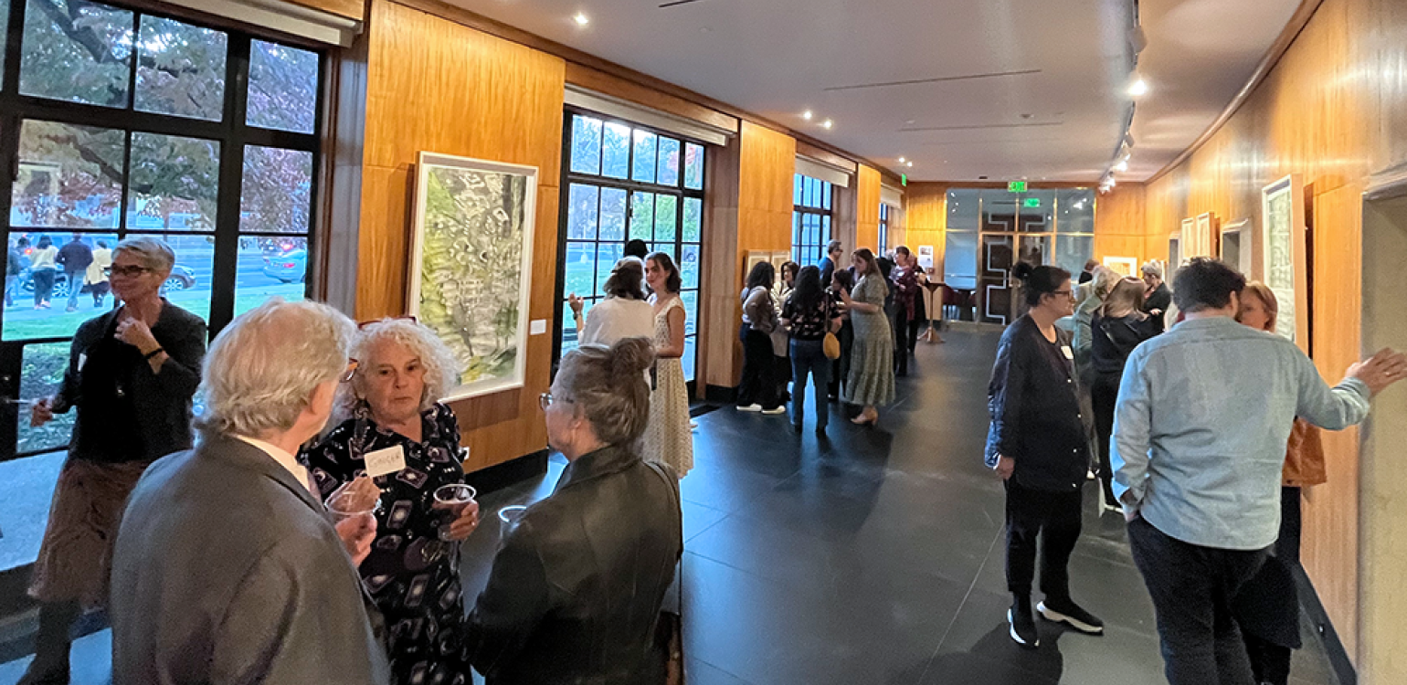 Reception with 22 people talking and looking at art