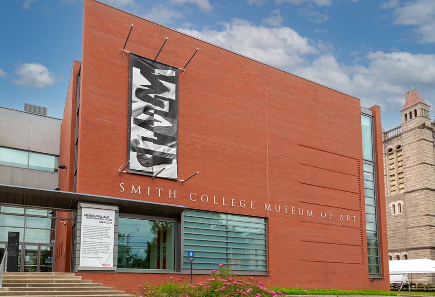 Exterior of modern brick building with an abstract black and white banner hanging on the front of the building