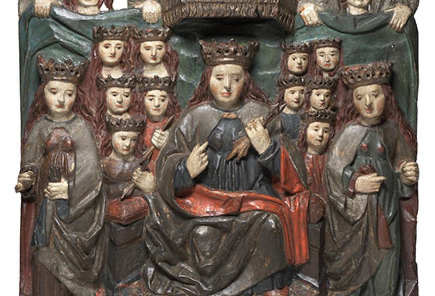 Painted wooden sculpture of a person with a crown with lots of people surrounding the person