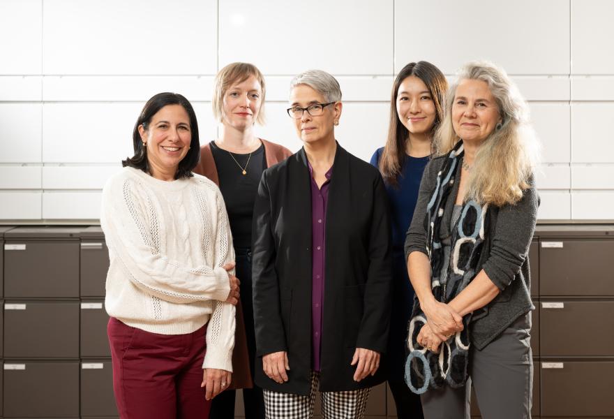 Five people standing in a line together for a photo