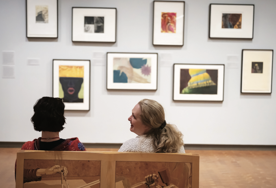 Two people on a bench in a gallery