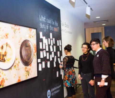 SCMA guests observing a work of art and reading talk back responses posted on the wall next to it.