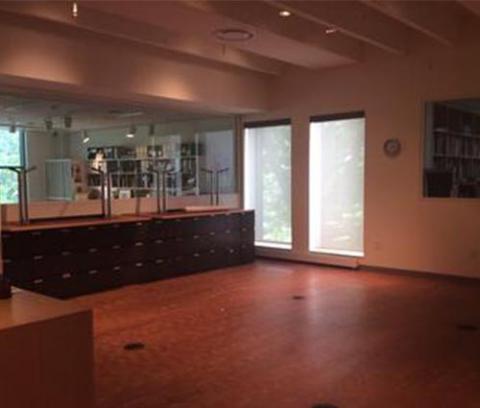 empty art gallery, with wood floors, black cabinets, and two rectangular windows