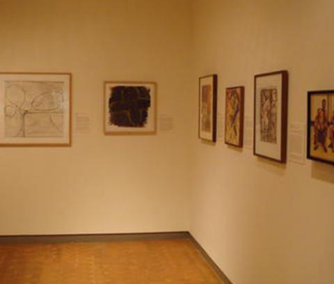 art gallery with two artworks hung on the back wall and four artworks hung on the right wall
