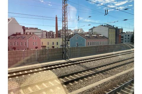 "train tracks in front of colorful houses"