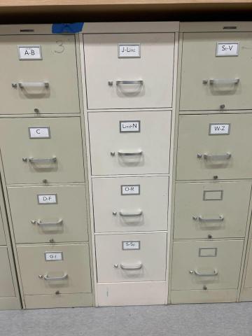 three tall beige file cabinets