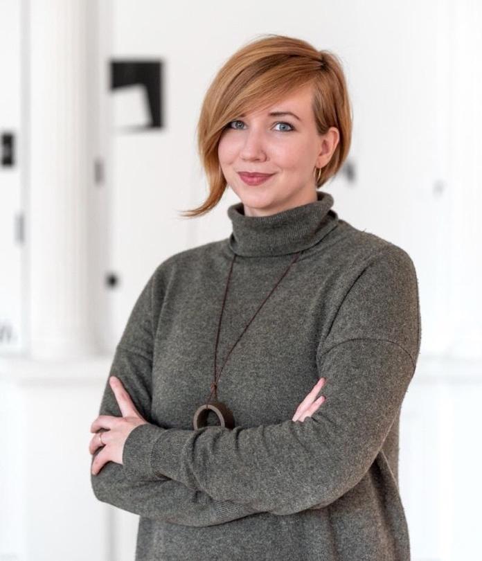 Portrait of a person with gray sweater, with hands crossed