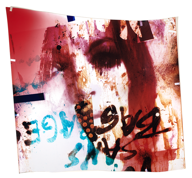 abstract image of a face painted in red with spraypainted text upside down at the bottom of the face