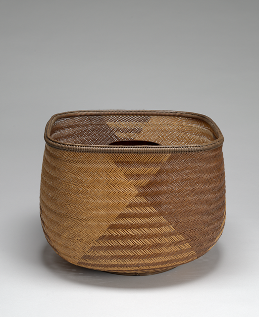Woven basket with beige and brown material, square at the top and circular at the bottom