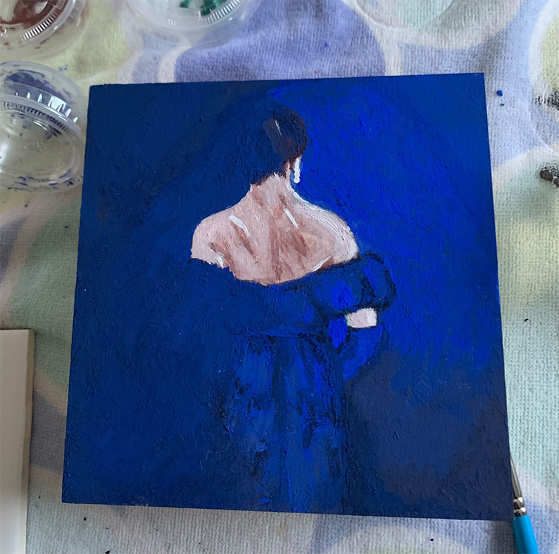back of woman in deep blue dress fading into the blue background