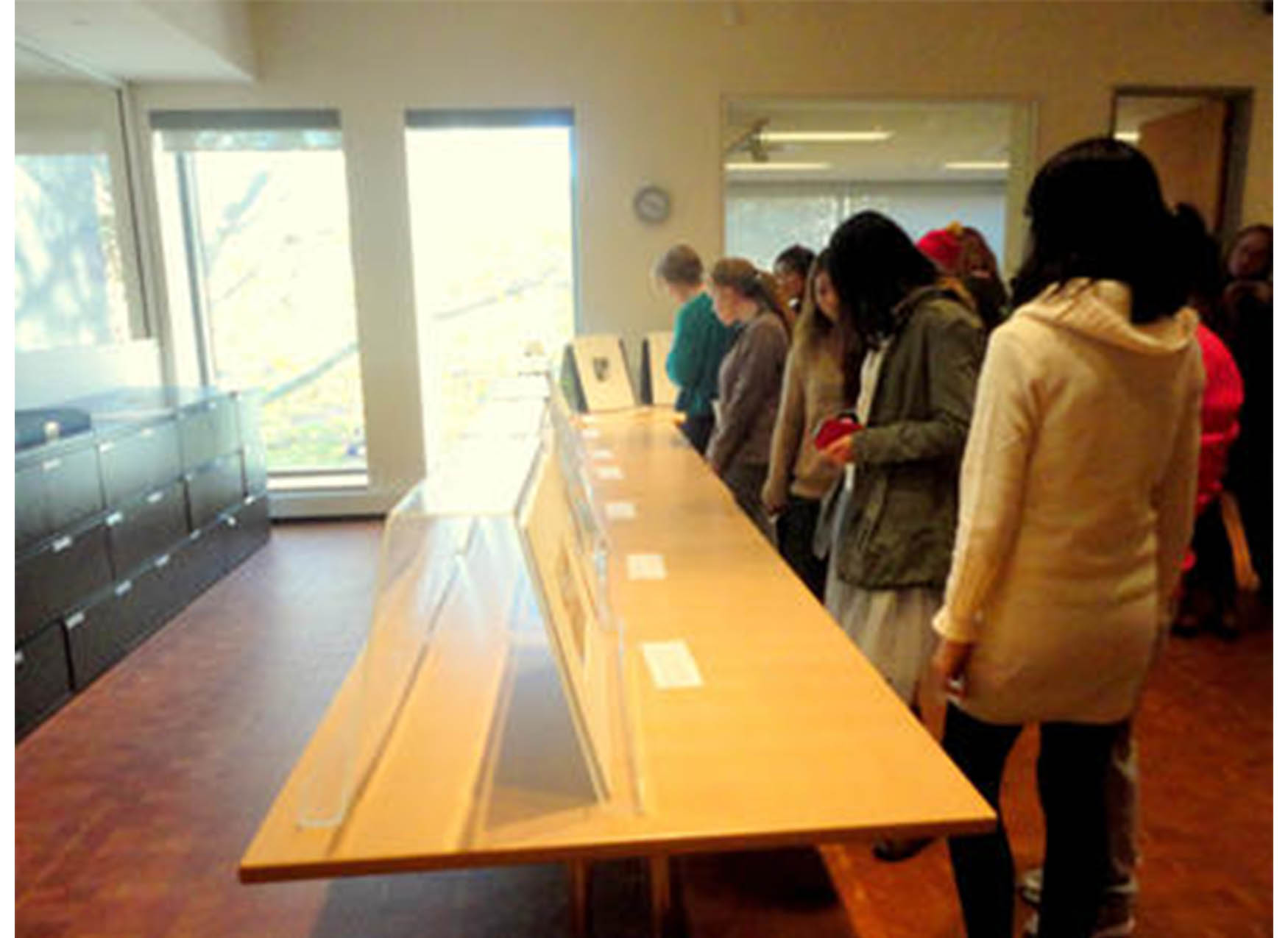 art gallery, with a table lined with prints and students looking at the art
